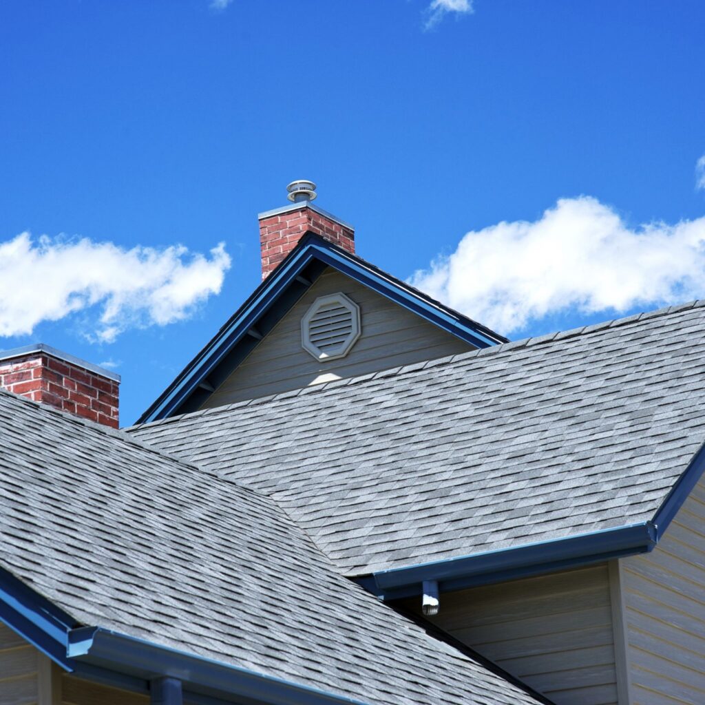 Residential home with gray architectural asphalt shingle roof and brick chimney in Philadelphia area – NEF Roofing & General Contracting