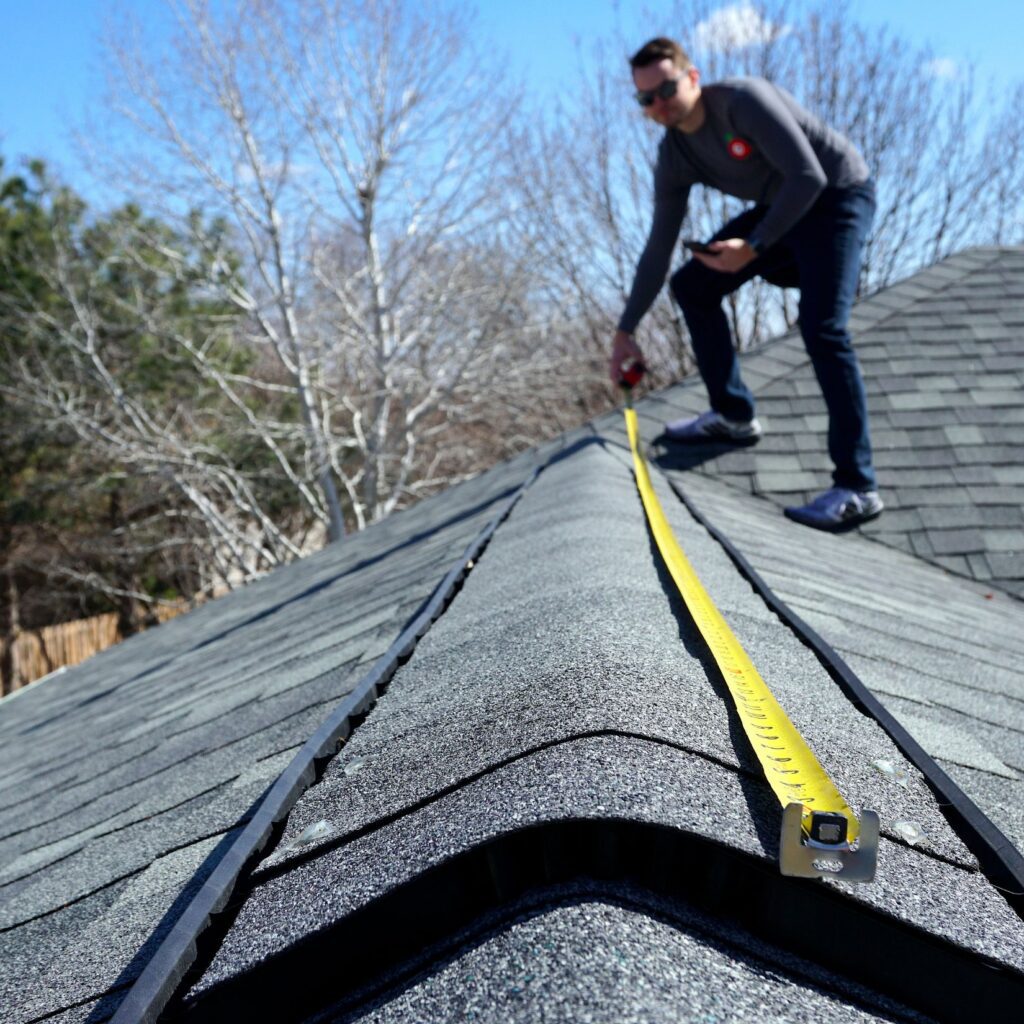 NEF Roofing contractor measuring asphalt shingle roof during inspection in Philadelphia or South Jersey